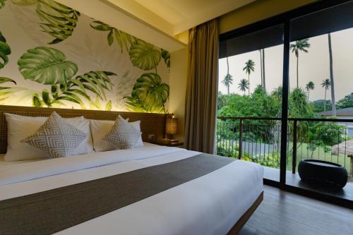 a bedroom with a large bed and a large window at Isla Amara Resort in El Nido