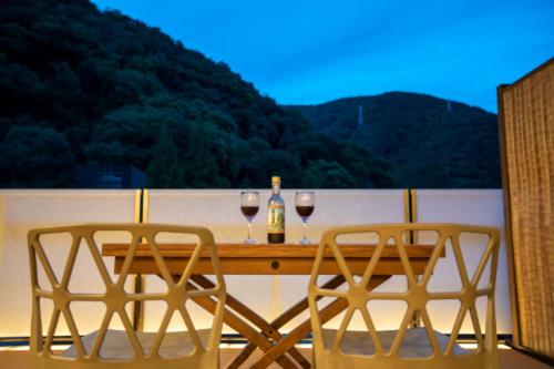 two glasses of wine sitting on a table on a balcony at Senkei in Hakone