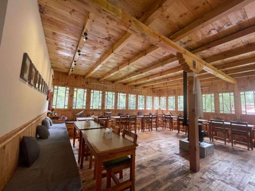 une salle à manger avec des tables et des chaises dans un bâtiment dans l'établissement Kongde Peak Guest House, à Phakding