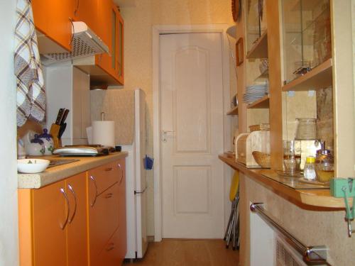 cocina con armarios naranjas y nevera blanca en Apartment Auseklis, en Riga