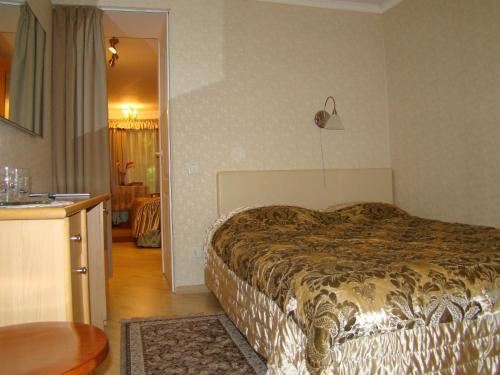 a hotel room with a bed and a kitchen at Apartment Auseklis in Rīga