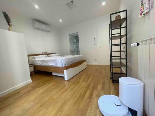 una camera da letto con un letto e un pavimento in legno di Maison moderne au calme a Saint-Vallier