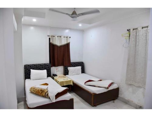 Jyoti Guest House, Bodh Gaya في بود جايا: غرفة بسريرين وسقف
