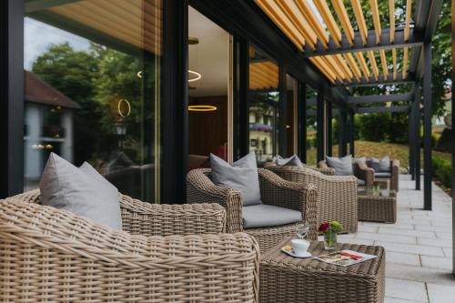 a group of wicker chairs and tables on a patio at Hotel Drei Quellen Therme in Bad Griesbach