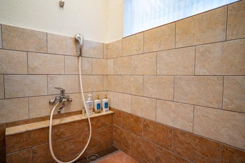 prysznic z wężem w łazience w obiekcie M&Unity w mieście Okinawa