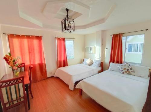 a bedroom with two beds and red curtains at Laciaville Resort and Hotel in Mactan