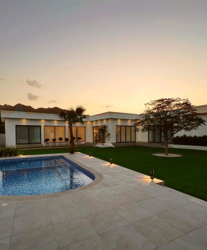 una casa con piscina en un patio en Quiet House villa, en Hatta