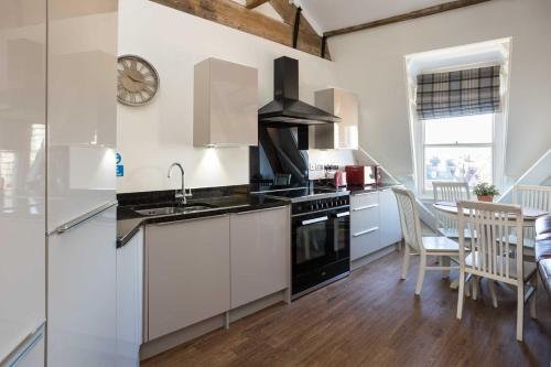 a kitchen with a sink and a stove top oven at Minster View Penthouse in York