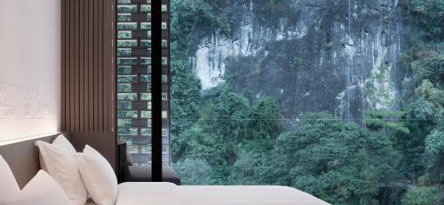 a bedroom with a large window with a mountain view at Yangshuo Sugar House in Yangshuo