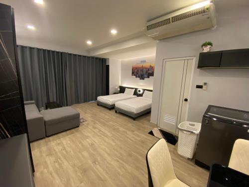 ein Wohnzimmer mit einem Bett und einem Sofa in der Unterkunft Bangyai Inn in Nonthaburi