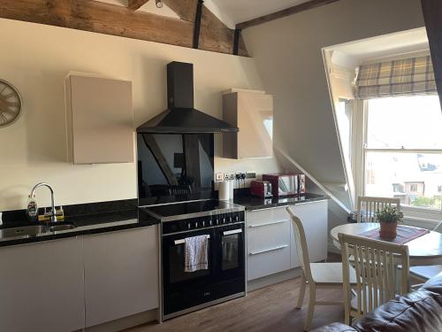 a kitchen with a stove and a sink and a table at Minster View Penthouse in York