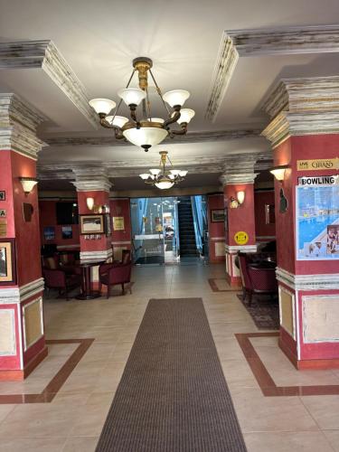 a lobby with red walls and a ceiling with a chandelier at Vintage De Lux, Top Location, 2Bdr Grand Monastery, Pamporovo in Pamporovo