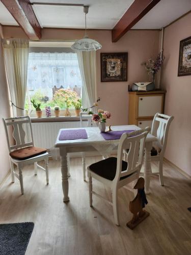 a dining room with a table and chairs and a window at Ferienhaus Katinka in Krummhörn