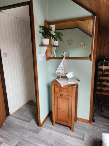 Zimmer mit einem Tisch und einem Spiegel an der Wand in der Unterkunft Ferienhaus Katinka in Krummhörn