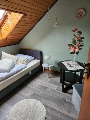 um quarto com uma cama e uma mesa com um vaso de flores em Ferienhaus Katinka em Krummhörn