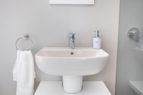 een witte badkamer met een wastafel en een handdoek bij On The Hills in Hillcrest