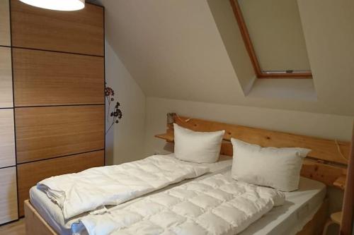 a bedroom with a bed with white sheets and pillows at Ferienwohnung LeoFix in Klütz