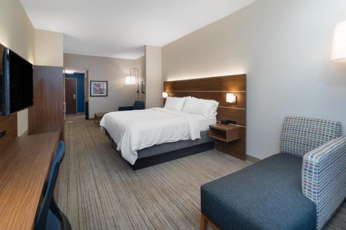 Habitación de hotel con cama, TV y sofá en Holiday Inn Express Hotel & Suites Talladega, an IHG Hotel, en Talladega