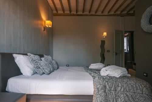 a bedroom with a bed with white sheets and pillows at Casa Grimaldi Hotel & Restaurant tre stelle S in Matelica
