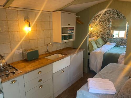 een keuken met een wastafel en een bed in een kamer bij Glen Erin Hut in Gillingham