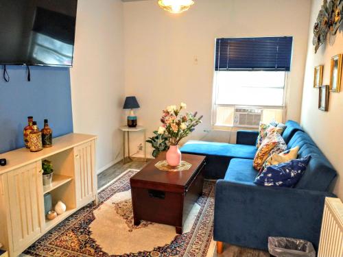 Explore New York from Queens في كوينز: غرفة معيشة مع أريكة زرقاء وطاولة