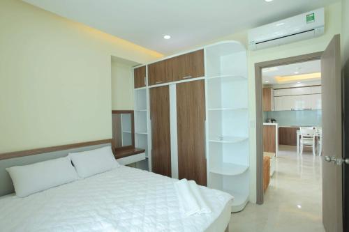 um quarto com uma cama branca e uma sala de estar em Cozy Apartment em Nha Trang