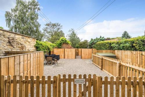 a wooden fence with a sign in a yard at Ivy Cottage Nestled Near The White Horse in York