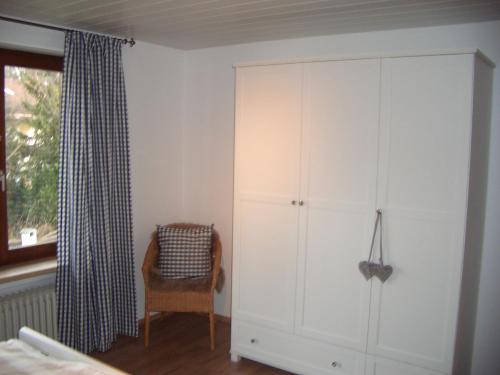 ein Schlafzimmer mit einem großen weißen Schrank und einem Stuhl in der Unterkunft Ferienwohnung Franziska in Garmisch-Partenkirchen