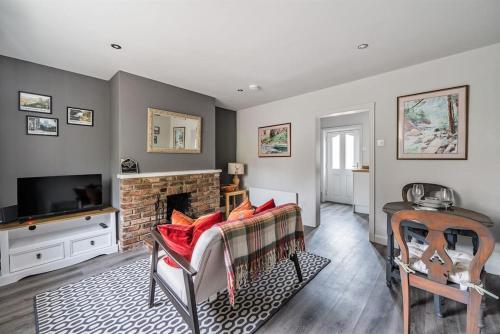 a living room with a fireplace and a television at Ivy Cottage Nestled Near The White Horse in York