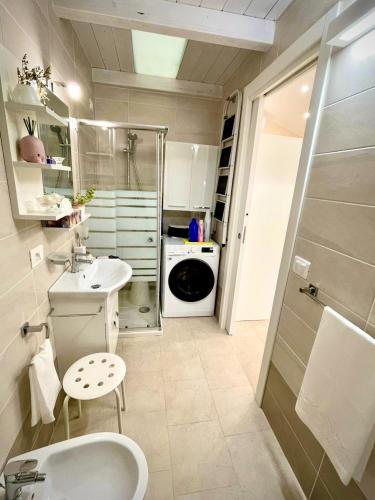 a bathroom with a sink and a washing machine at Loft Agata - host Marco cell.339/3860587 in Polistena