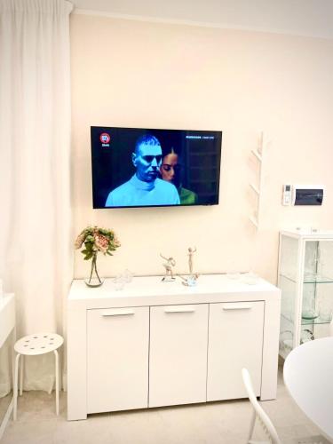 a bathroom with a white sink and a tv on the wall at Loft Agata - host Marco cell.339/3860587 in Polistena