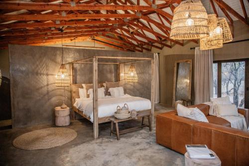 sypialnia z dużym łóżkiem i kanapą w obiekcie Minara Private Boutique Game Lodge w mieście Dinokeng Game Reserve