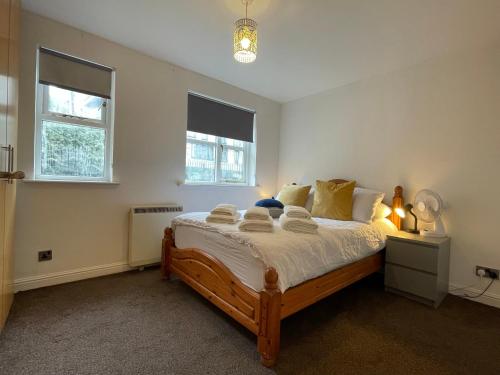 ein Schlafzimmer mit einem großen Bett in einem Zimmer mit zwei Fenstern in der Unterkunft Surrey Docks SE16 near Canada Water n Easy Access Canary Wharf in London