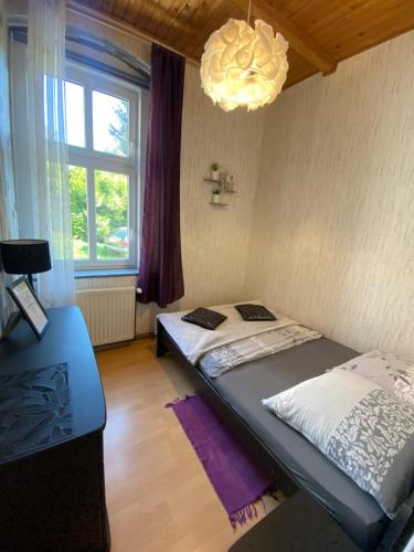 a bedroom with a bed and a chandelier at Apartament Górski 90m2 blisko centrum i wyciagu in Szklarska Poręba