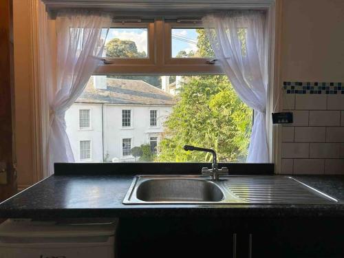 a kitchen counter with a sink and a window at The ideal retreat for some vitamin sea! in Sandgate