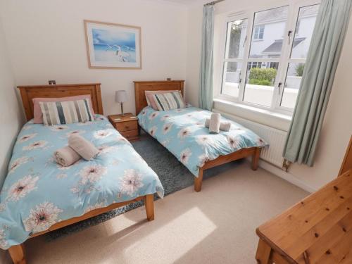 a bedroom with two beds and a window at 3 Strawberry Close in Little Haven