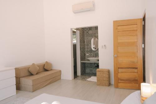 a living room with a couch and a bathroom at Villa Aurora Siargao - Villa 1 in General Luna