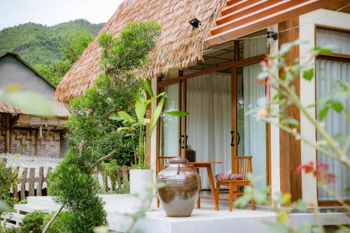 a house with a large vase sitting outside of it at Hue Crown A Luoi Retreat in Ha Tia
