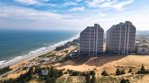 two tall buildings on a beach next to the ocean at Mandala Cham Bay Mũi Né view biển in Ấp Thiẹn Ái