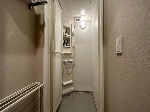 a bathroom with a walk in shower next to a door at Lake Side Inn MIRAHAKONE in Moto-hakone