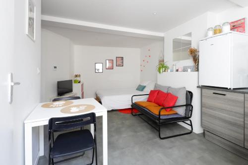 Habitación pequeña con cama, mesa y sillas en Charmant studio, au cœur de la ville de Riom en Riom