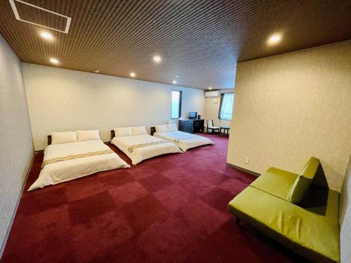 Cette chambre comprend 2 lits et un canapé. dans l'établissement NARITA HOTEL KAKUREGA - Vacation STAY 72264v, à Narita