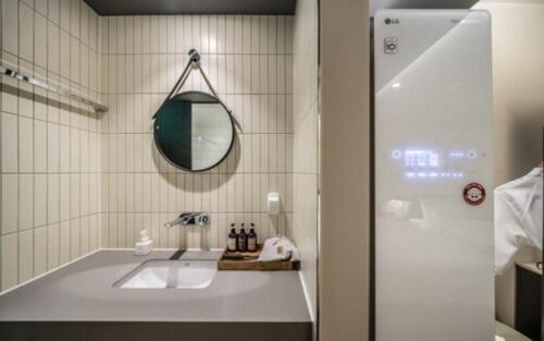 a bathroom with a sink and a mirror at Brown Dot Hotel Sajik Baseball Stadium in Busan