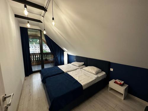 Schlafzimmer mit einem Bett mit blauer Wand in der Unterkunft Areguni Cottage in Dilidschan