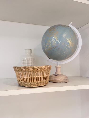un globe et un panier sur une étagère dans l'établissement Salut Le Petit Gite, à Carcassonne