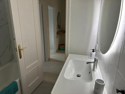 uma casa de banho com um lavatório branco e uma banheira em Apartamento recién reformado en Ezcaray em Ezcaray