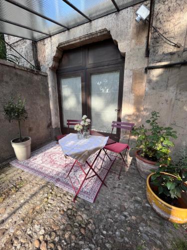 a patio with a table and chairs on a rug at Salut Le Petit Gite in Carcassonne