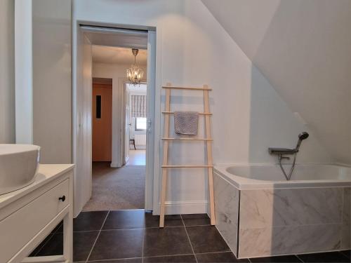 ein Badezimmer mit einem Waschbecken und einer Badewanne in der Unterkunft Villa Dageraad in De Panne