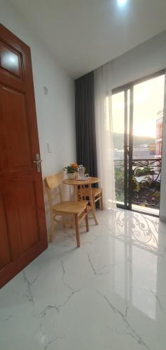 een eetkamer met een tafel en een deur met uitzicht bij LUCKY HOTEL in Vung Tau