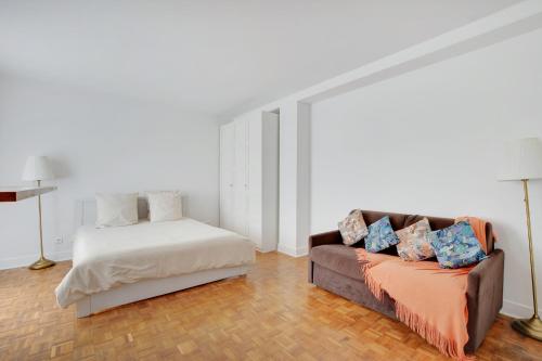 a living room with a couch and a bed at Maison de la Radio - Tour Effeil in Paris